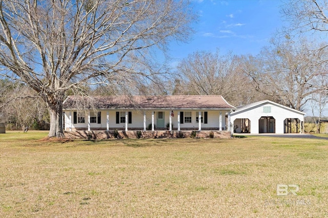 ranch-style house with covered porch, a front yard, and a detached garage