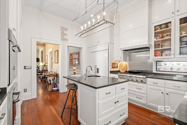 212 S Cedar St, Mobile, AL 36602 - kitchen with stainless steel gas stovetop, a sink, a breakfast bar area, dark countertops, and white cabinetry