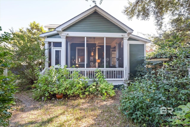 rear view of property featuring a sunroom