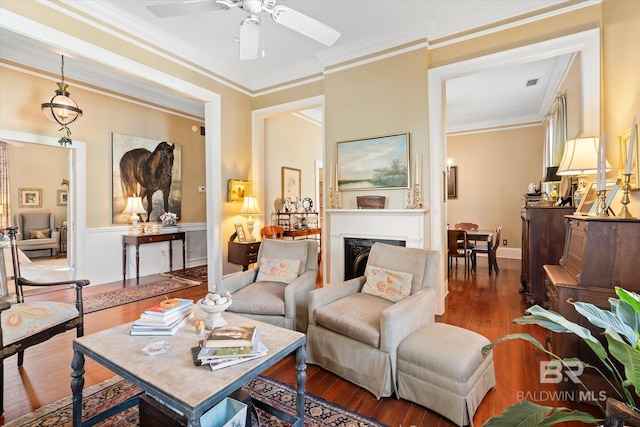 living room featuring crown molding, wood-type flooring, and ceiling fan