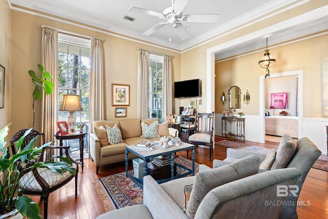 living room with ornamental molding, ceiling fan, wood-type flooring, and plenty of natural light