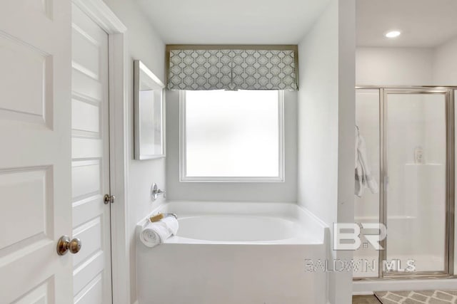 full bath featuring a bath and a shower stall