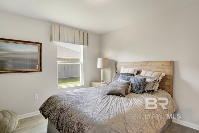bedroom featuring baseboards and wood finished floors
