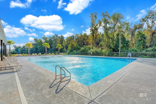 pool with fence and a patio