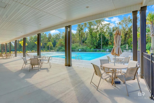 outdoor pool featuring outdoor dining space and a patio