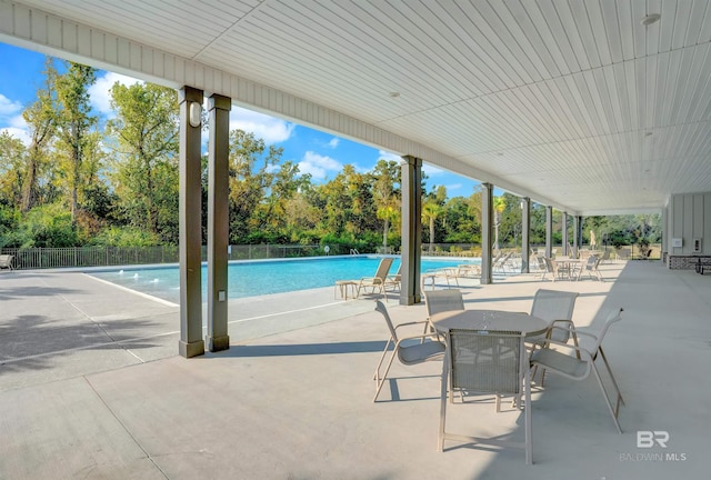 pool featuring fence and a patio area
