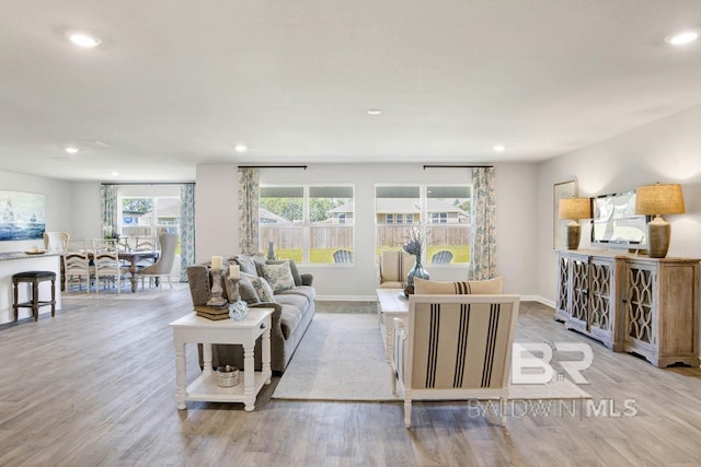 living room with recessed lighting, baseboards, and wood finished floors