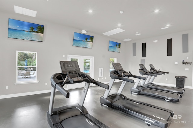 exercise room featuring baseboards, visible vents, a high ceiling, and recessed lighting