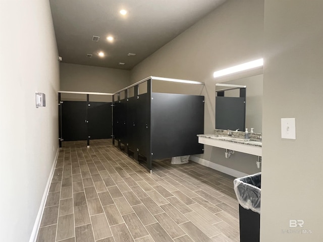 bathroom featuring baseboards, recessed lighting, and wood finish floors