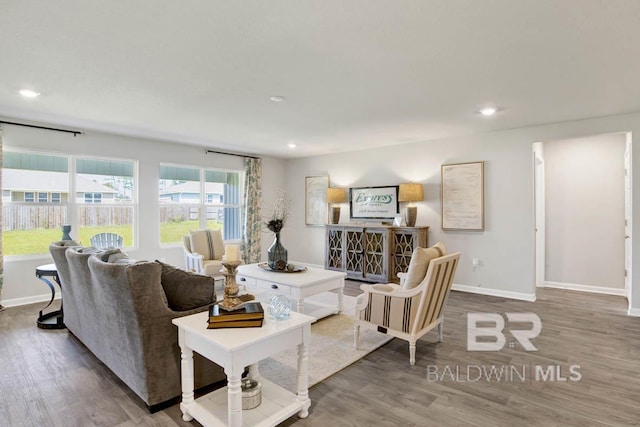 living area with baseboards, wood finished floors, and recessed lighting