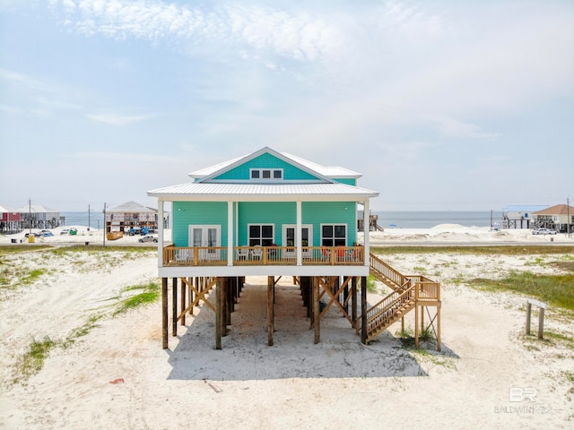 back of house featuring a porch and a water view