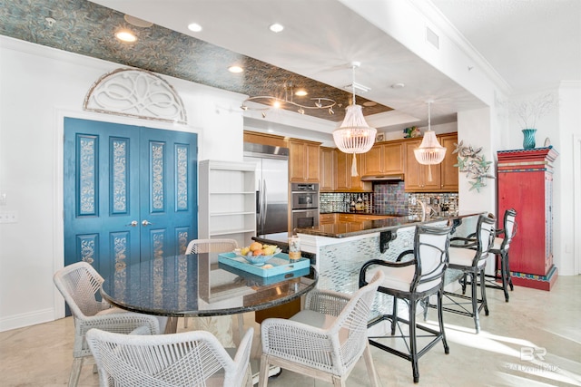 kitchen featuring kitchen peninsula, hanging light fixtures, a breakfast bar area, appliances with stainless steel finishes, and crown molding