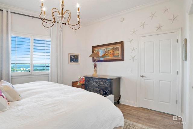 bedroom featuring crown molding, hardwood / wood-style flooring, and a chandelier