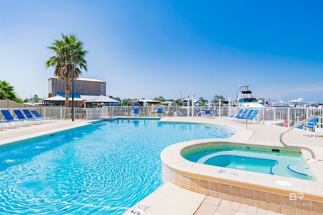 view of swimming pool with a hot tub and a patio