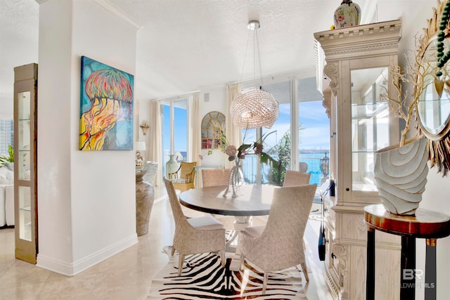 dining room featuring crown molding, a textured ceiling, a chandelier, and light tile patterned floors