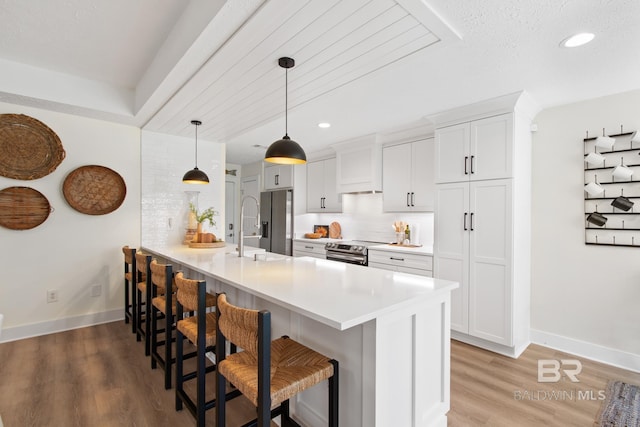 5100 Pine Way, Orange Beach, AL 36561 - kitchen featuring baseboards, stainless steel appliances, a breakfast bar, and a sink