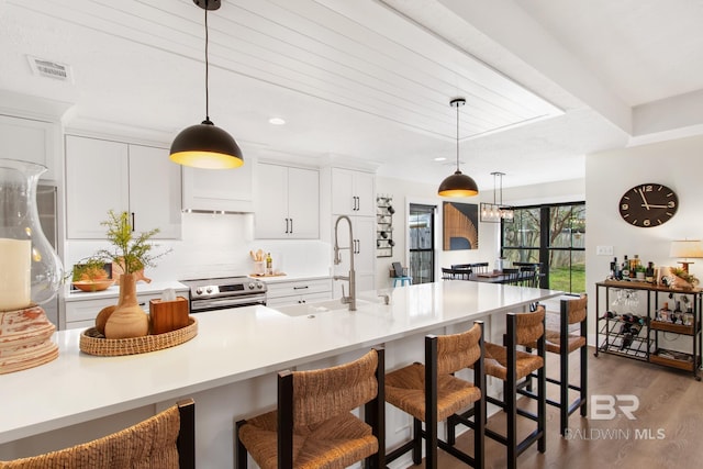 5100 Pine Way, Orange Beach, AL 36561 - kitchen featuring stainless steel range with electric cooktop, a kitchen breakfast bar, wood finished floors, visible vents, and a sink