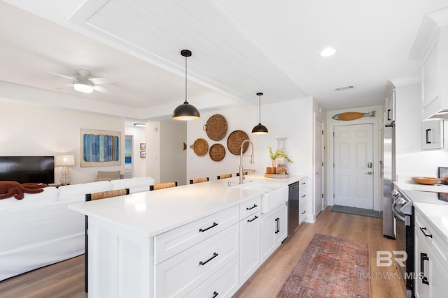 5100 Pine Way, Orange Beach, AL 36561 - kitchen with light countertops, a sink, light wood-style floors, a peninsula, and appliances with stainless steel finishes