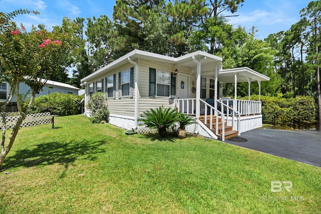 manufactured / mobile home featuring a porch and a front yard