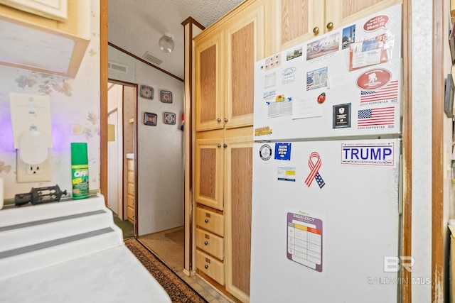 interior space featuring white refrigerator, crown molding, a textured ceiling, and vaulted ceiling