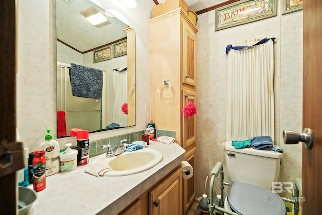 bathroom featuring toilet, ornamental molding, vanity, and a textured ceiling