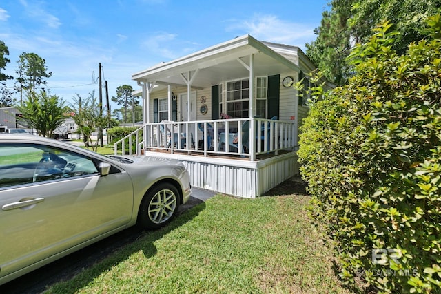 view of home's exterior featuring covered porch and a yard