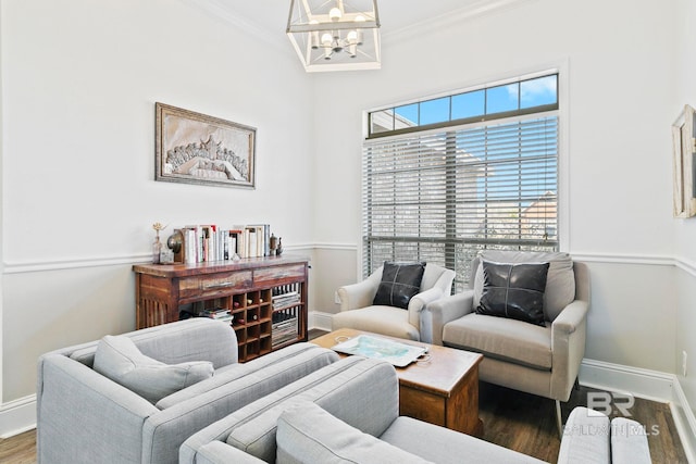 living room with crown molding, wood-type flooring, and an inviting chandelier