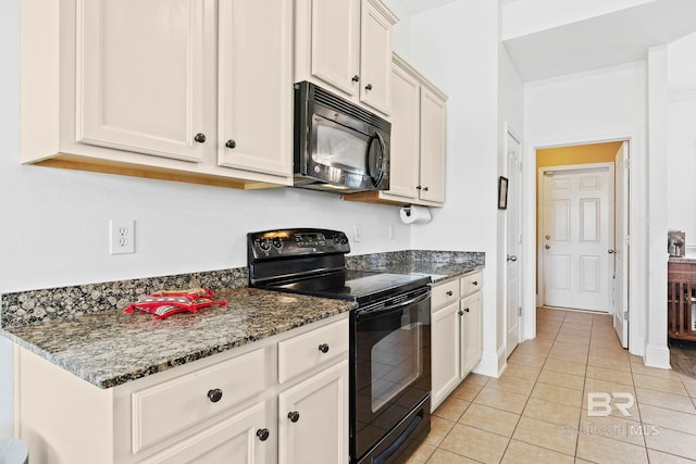 kitchen with dark stone countertops, black appliances, white cabinets, and light tile patterned flooring