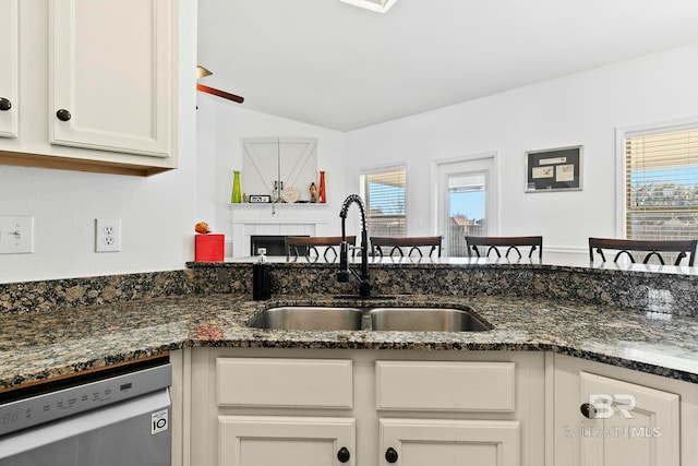 kitchen featuring white cabinetry, sink, stainless steel dishwasher, and a healthy amount of sunlight