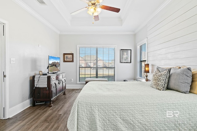 bedroom with a raised ceiling, dark hardwood / wood-style flooring, ornamental molding, and ceiling fan