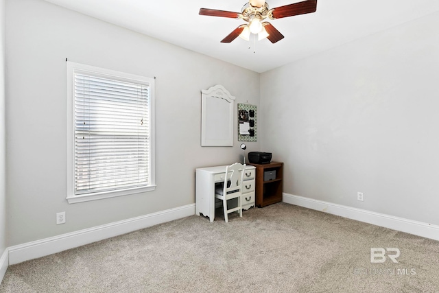 unfurnished office featuring light carpet and ceiling fan