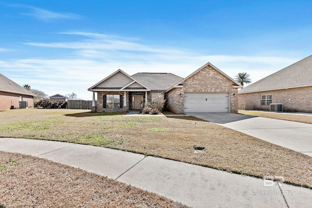 view of front of home featuring a garage, a front lawn, and central air condition unit