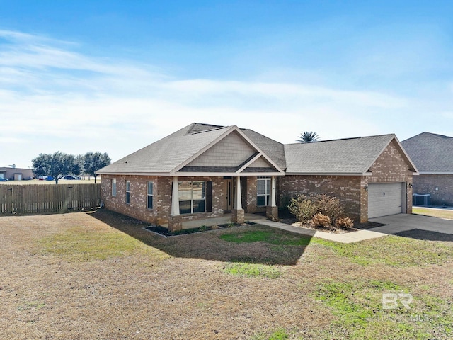 view of front of home with a garage, central AC unit, and a front lawn