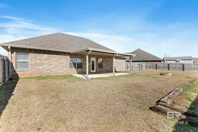 rear view of house featuring a patio area and a lawn