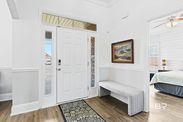 foyer entrance featuring hardwood / wood-style flooring, crown molding, and ceiling fan