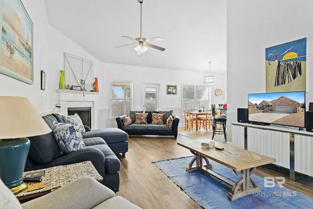 living room featuring vaulted ceiling, ceiling fan, and light wood-type flooring