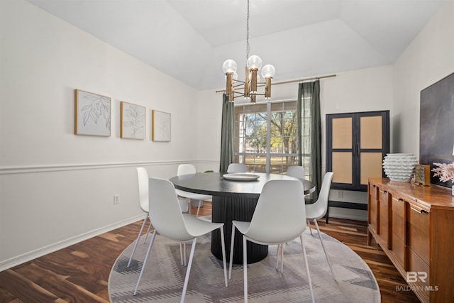 dining space featuring dark wood-style floors, baseboards, lofted ceiling, and an inviting chandelier