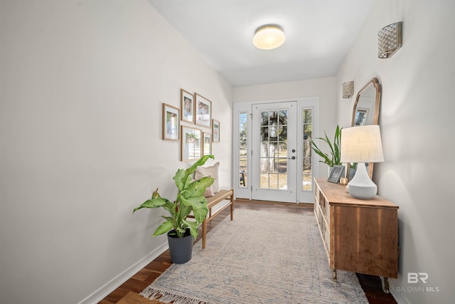 doorway to outside with baseboards and wood finished floors