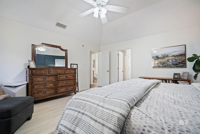 bedroom featuring visible vents, ceiling fan, vaulted ceiling, ensuite bathroom, and light wood-style floors