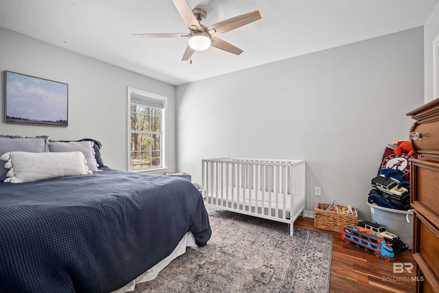 bedroom featuring ceiling fan, baseboards, and wood finished floors