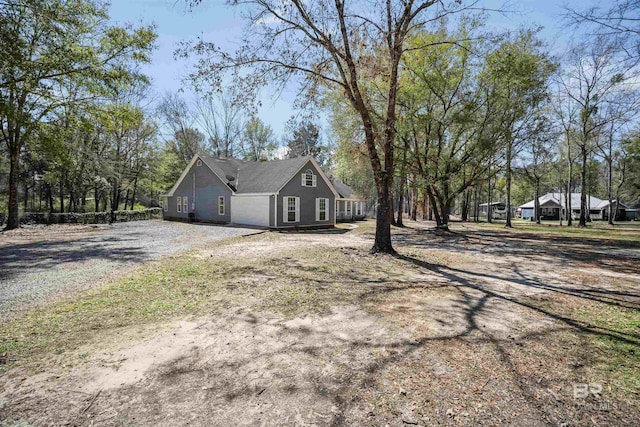 view of side of home with gravel driveway