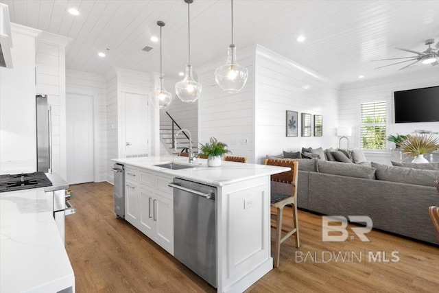 kitchen with a sink, white cabinets, wood ceiling, appliances with stainless steel finishes, and open floor plan