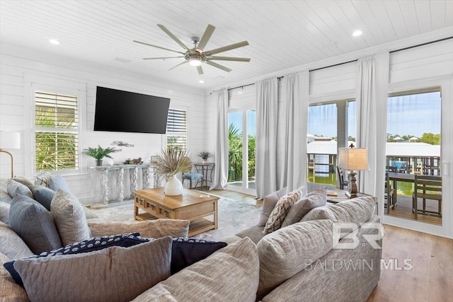 living room with a wealth of natural light, wood ceiling, wood finished floors, and a ceiling fan