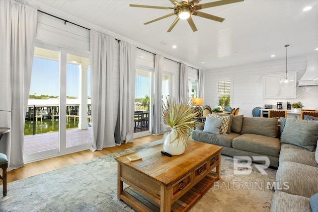 living room with recessed lighting, plenty of natural light, light wood-style flooring, and a ceiling fan