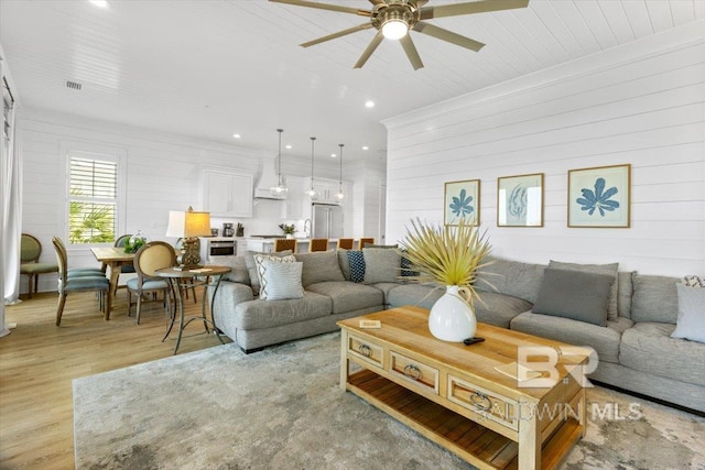 living room with recessed lighting, a ceiling fan, and light wood-style floors