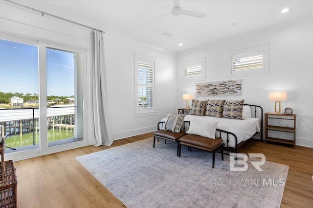 bedroom featuring wood finished floors, baseboards, recessed lighting, ornamental molding, and access to exterior