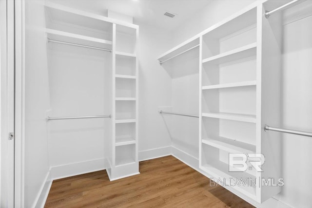 walk in closet featuring visible vents and wood finished floors