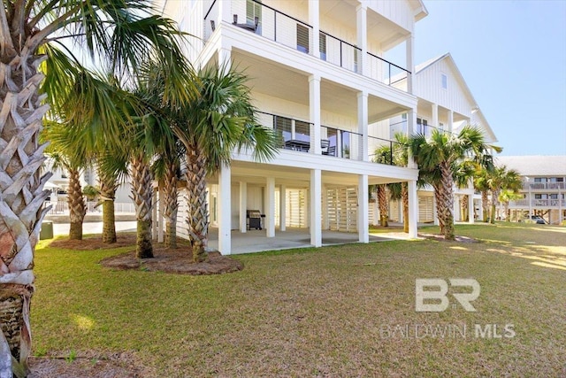 back of property featuring a patio area and a lawn