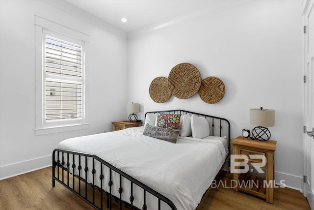 bedroom with recessed lighting, multiple windows, wood finished floors, and baseboards