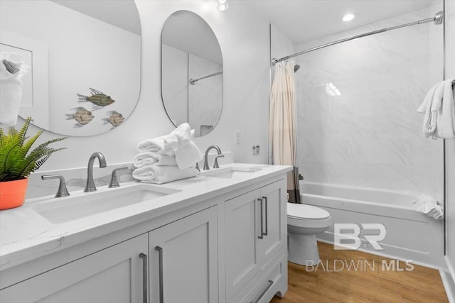 bathroom with a sink, shower / bath combo with shower curtain, toilet, and double vanity